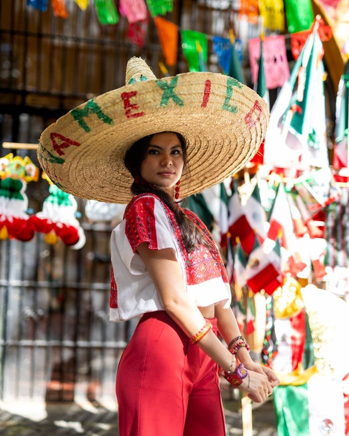 Young woman in vibrant Mexican attire celebrates at a festive street market.