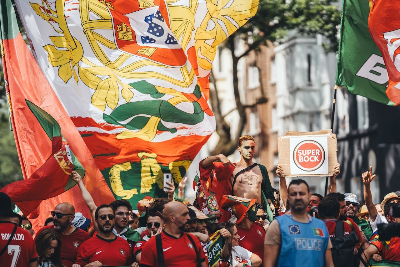 Energetic crowd of Portuguese fans with flags cheering during street parade.